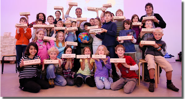 Schulklasse mit beschrifteten Holzquadern